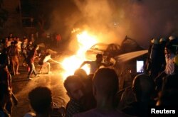 People extinguish a fire from a blast outside the National Cancer Institute, Cairo, Egypt Aug. 4, 2019.