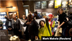 Manifestantes protestan dentro de Center City Starbucks, donde dos hombres negros fueron arrestados, en Filadelfia, Pensilvania, el 16 de abril de 2018. REUTERS / Mark Makela