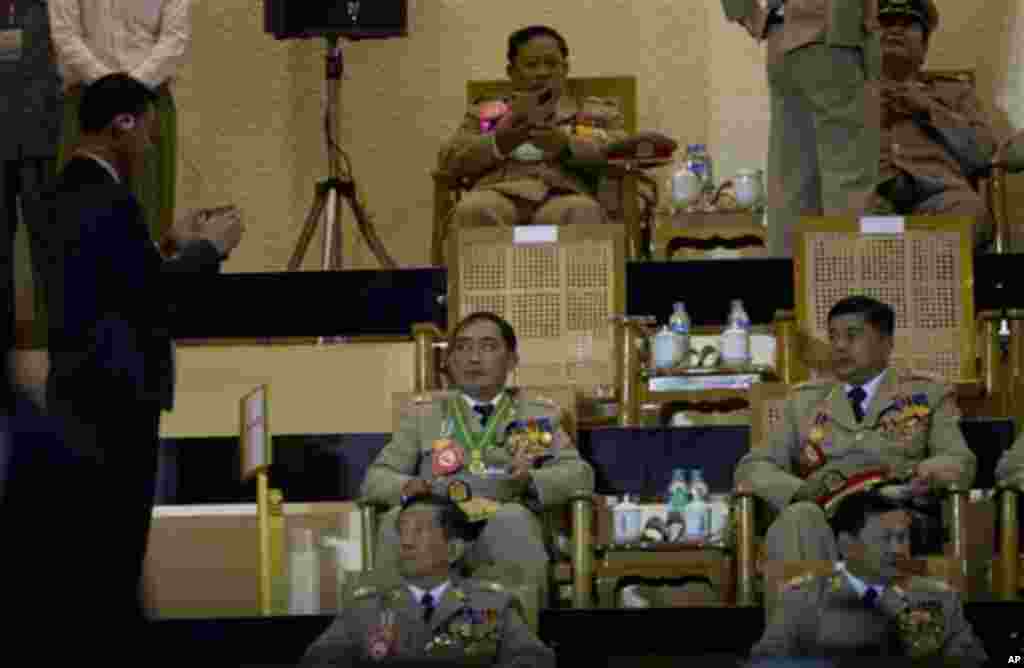 A security officer takes pictures of army officers with a mobile phone during a ceremony to mark Myanmar's 67th anniversary of Independence Day in Naypyitaw, Myanmar, Sunday, Jan. 4, 2015. (AP Photo/Gemunu Amarasinghe)