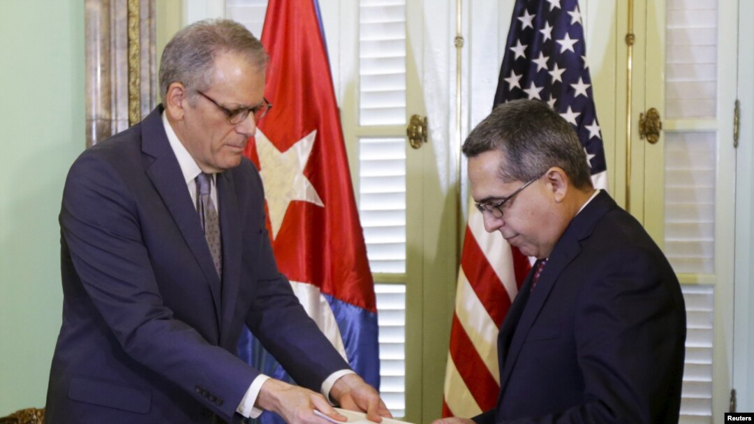 Duta Besar AS untuk Kuba Jeffrey DeLaurentis (kiri) memberikan surat dari Presiden AS Barack Obama kepada Presiden Kuba Raul Castro di Havana. (Foto: Dok)