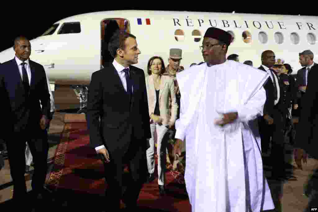 Le président français Emmanuel Macron et la ministre française de la Défense, Florence Parly, sont accueillis par le président du Niger Mahamadou Issoufou à leur arrivée à l'aéroport de Niamey le 22 décembre 2017.