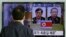A South Korean man watches a TV news report about South Korean Kim Kuk Gi, left, and Choe Chun Gil detained in North Korea, at the Seoul Railway Station, March 27, 2015.