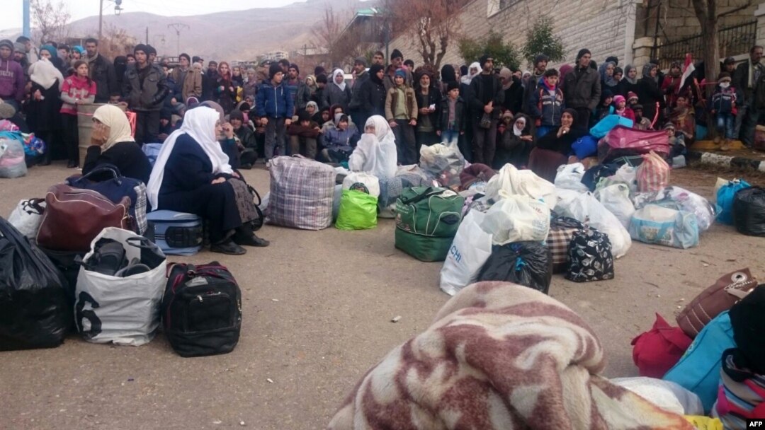 Syrians wait for the arrival of an aid convoy, Jan. 11, 2016, in the besieged town of Madaya as part of a landmark six-month deal reached in September for an end to hostilities in those areas in exchange for humanitarian assistance.