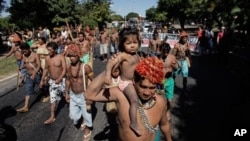 Munduruku Indians march to the Ministry of Mines and Energy, in Brasilia, Brazil, Tuesday, June 11, 2013. The group along with other had been occupying the controversial Belo Monte dam being built in the Amazon on the Xingu River. They were recently flown