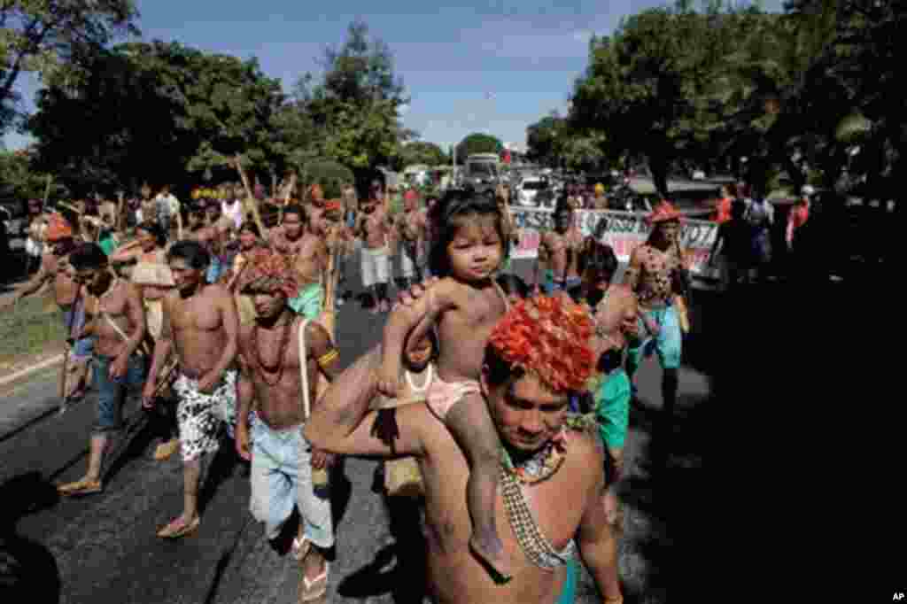 Munduruku Indians march to the Ministry of Mines and Energy, in Brasilia, Brazil, Tuesday, June 11, 2013. The group along with other had been occupying the controversial Belo Monte dam being built in the Amazon on the Xingu River. They were recently flown