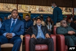 Corneille Nangaa, center, leader of the Congo River Alliance, sits alongside Bertrand Bisimwa, right, leader of the M23 rebel group, during a rally in Bukavu, DRC, on Feb. 27, 2025, before two explosions rocked the area.