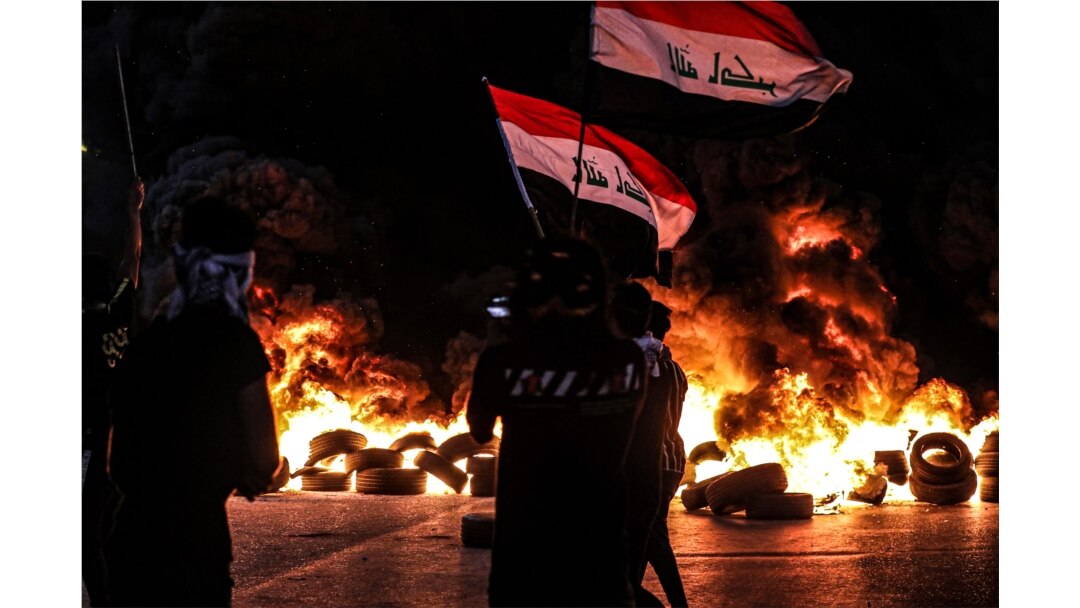 FILE - Anti-government protesters demand free elections and an end to corruption outside the provincial council building in Basra, Iraq, Aug. 17, 2020.