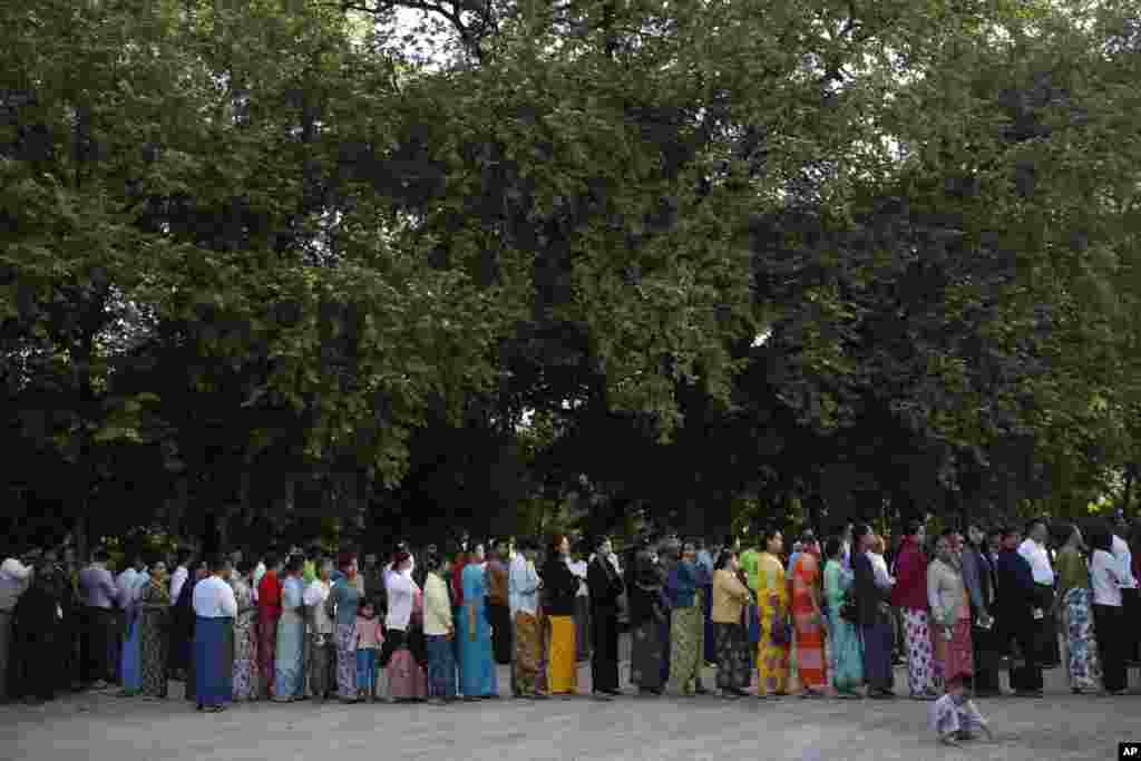 Warga berdiri di luar TPS di Mandalay, 8 November 2015.