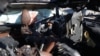 A man checks a car hit by an Israeli strike in Khan Yunis, Gaza Strip, on Nov. 30, 2024, in which five people were killed, including three World Central Kitchen aid workers.