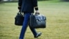 FILE - An aide carries nuclear codes to Marine One, the president's helicopter, on the South Lawn of the White House in Washington, Jan. 20, 2021. President Donald Trump left from there before Joe Biden's inauguration as president.