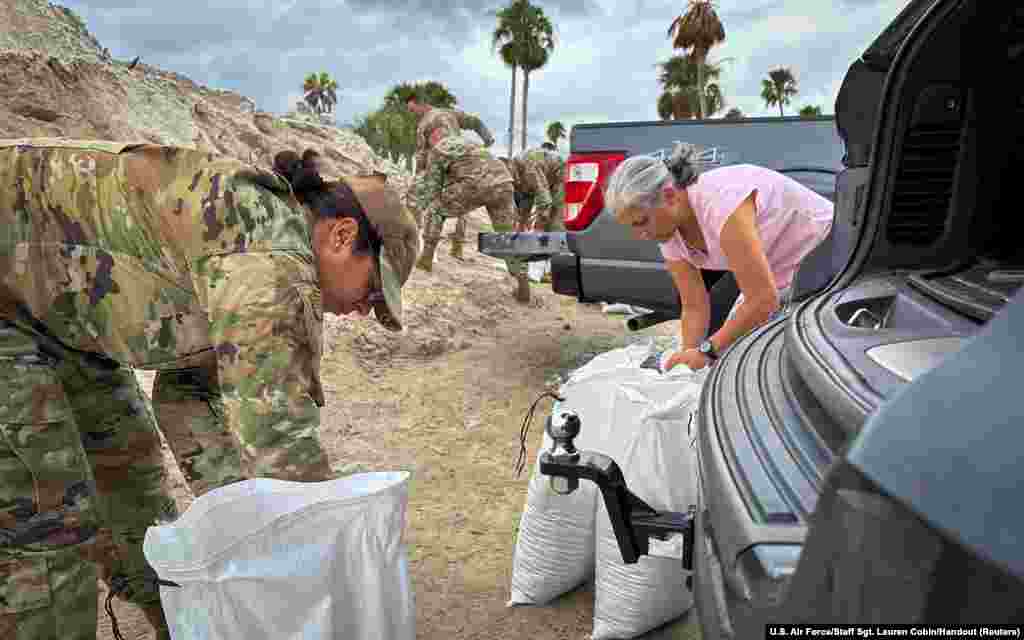 A U.S. Air Force airman fills sandbags with family members ahead of Hurricane Milton at MacDill Air Force Base in Tampa, Florida, Oct. 7, 2024.