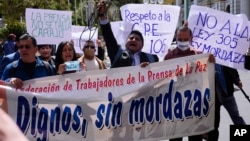 Periodistas de la Federación de Prensa de La Paz sostienen una pancarta mientras protestan contra una propuesta de ley impulsada por los legisladores del oficialismo que regularía a la prensa frente al palacio de gobierno en La Paz, Bolivia, el miércoles 12 de abril de 2023.