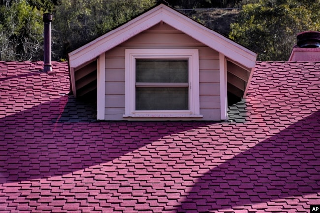 Fire retardant from crews battling the Palisades Fire coats the roof of a home in Mandeville Canyon on Monday, Jan. 13, 2025, in Los Angeles.