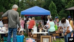A crowd looks through items at the World's Longest Yard Sale, which stretches from Alabama to Michigan, at its southernmost point in Gadsden, Ala., on Aug. 6, 2020. 