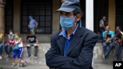 Un hombre, con un tapabocas, espera un autobús en Caracas, Venezuela. Junio 20, 2020.