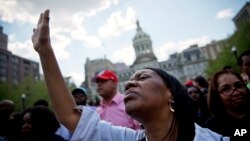 Patricia Freeman ora durante una manifestación frente a la alcaldía de Baltimore, el domingo, luego de ser levantado el toque de queda.