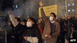 Protesters chant slogans and hold a placard reading in Farsi "Your mistake was unintentional, your lie was intentional," during an anti-govenrnment rally outside Amir Kabir University, in Tehran, Iran, Jan. 11, 2020.