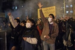 Protesters chant slogans and hold a placard reading in Farsi "Your mistake was unintentional, your lie was intentional," during an anti-govenrnment rally outside Amir Kabir University, in Tehran, Iran, Jan. 11, 2020.
