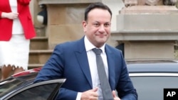 ARCHIVO - El primer ministro irlandés Leo Varadkar baja de su auto para ir al encuentro de la primera ministra de Irlanda del Norte, Michelle O'Neill, y la viceprimera ministra Emma Little-Pengelly, en Belfast, Irlanda del Norte, 5 de febrero de 2024. 