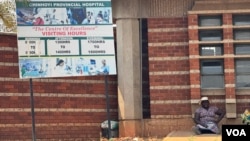 A woman sits near the entrance of Chinhoyi Provincial Hospital, where women have begun receiving treatment for obstetric fistula, in Chinhoyi, Zimbabwe, some 150 kms west of the capital Harare, Sept. 17, 2024. (Columbus Mavhunga/VOA)