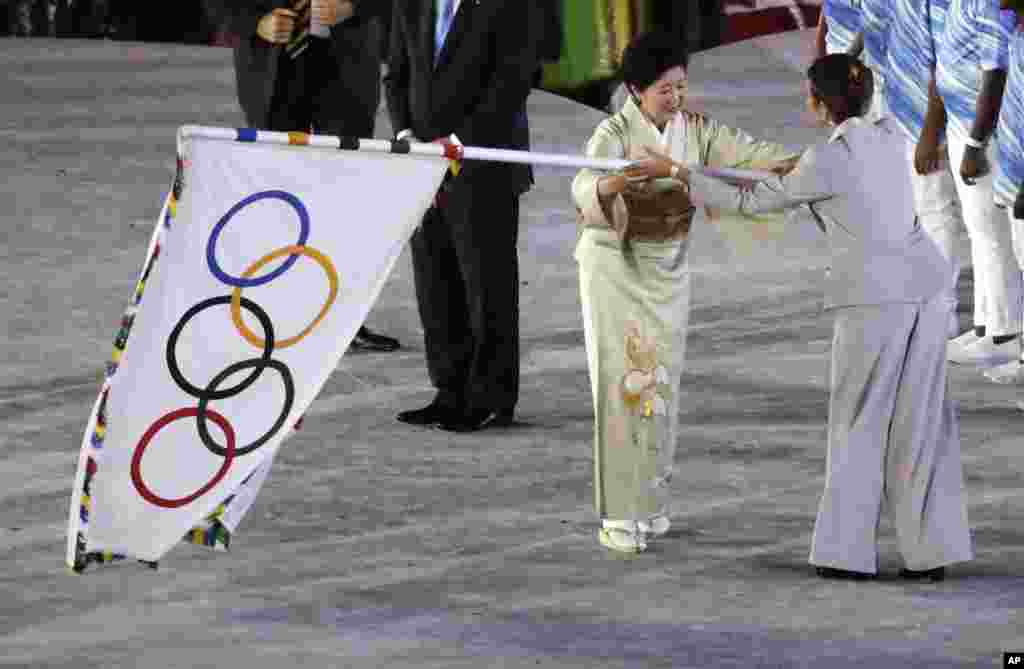 Gubernur Tokyo Yuriko Koike menyerahkan bendera Olimpiade dalam upacara penutupan Olimpiade Musim Panas 2016 di Rio de Janeiro, Brazil (21/8). (AP/Charlie Riedel)