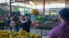 ARCHIVO - Trabajadores llenan una canasta con papayas en el mercado de la Cooperativa Cecosesola en Barquisimeto, Venezuela, el 19 de enero de 2025.