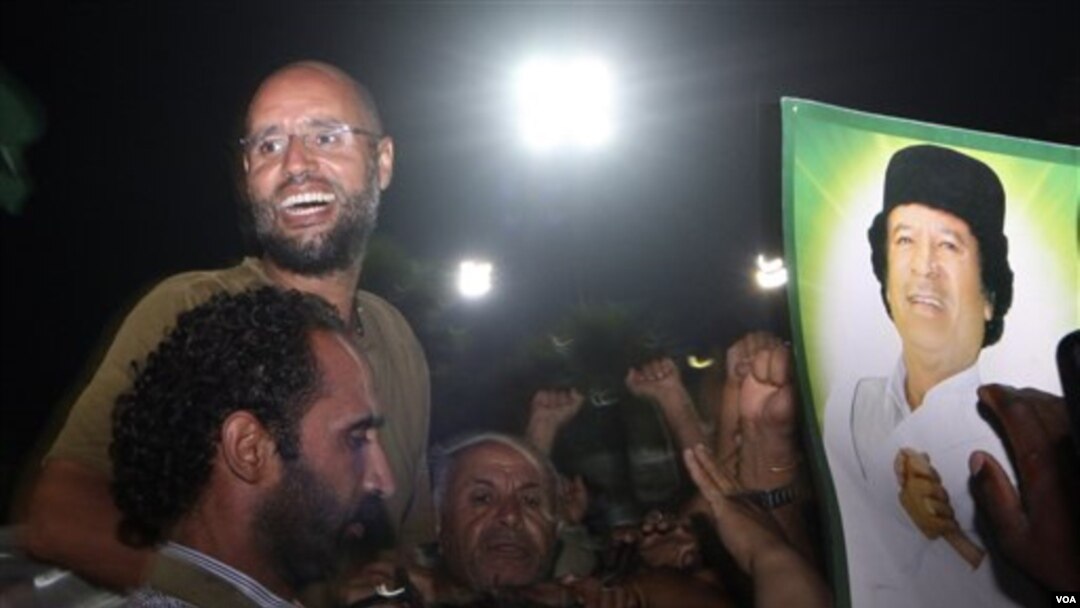 Putera Moammar Gaddafi, Seif al-Islam (berkacamata) menyapa para anggota pasukan pro-Gaddafi di ibukota Tripoli (23/8). Kemunculan Seif di Tripoli sekaligus menyanggah klaim pemberontak Libya sebelumnya bahwa Seif al-Islam telah ditangkap.