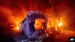 Flames from the LNU Lightning Complex fires consume a home in unincorporated Napa County, Calif., Aug. 19, 2020. 