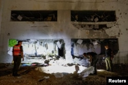 Israeli rescue force members inspect the site where a missile fired from Iran towards Israel hit a school building in central Israel, Oct. 1, 2024.