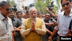 Kandidat Perdana Menteri India dari oposisi nasionalis Hindu partai Bharatiya Janata (BJP), Narendra Modi (tengah), tiba di rumah kediaman ibunya di Gandhinagar, negara bagian Gujarat, untuk meminta restu (16/5). Narendra Modi, diperkirakan kalangan luas akan menjadi perdana menteri India, menyusul kemenangan partainya dalam Pemilu 2014.