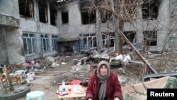 A local resident cooks food in Mariupol