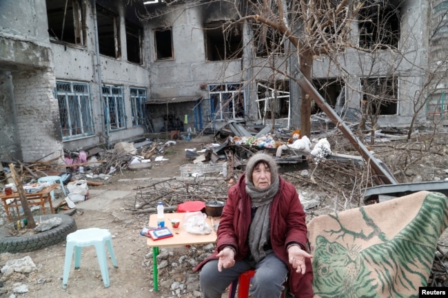 Cư dân địa phương Valentina Popyi, 75 tuổi, đang tìm kiếm nơi trú ẩn trong một ngôi nhà trẻ em bị hư hại, nói chuyện với những người hàng xóm ở thành phố cảng phía nam Mariupol, Ukraine ngày 1 tháng 4 năm 2022.