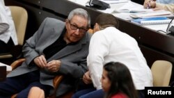 Cuba's former President Raul Castro, center left, talks to his grandson and bodyguard Raul Rodriguez Castro during a session of the National Assembly in Havana, Dec. 21, 2018.