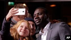 L'acteur Omar Sy pose avec des fans avant la première du film "Inferno" à Berlin, le 10 octobre 2016.