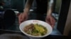 Chef Hung serves pineapple beef noodle at his restaurant in Taipei, Taiwan, March 10, 2021. 
