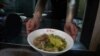 Chef Hung serves pineapple beef noodle at his restaurant in Taipei, Taiwan, March 10, 2021. 