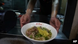 Chef Hung serves pineapple beef noodle at his restaurant in Taipei, Taiwan, Wednesday, March 10, 2021. Hung Ching Lung, a Taipei chef, has created a pineapple beef noodle soup at his eponymous restaurant Chef Hung, in what he says is a modest…