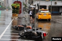 People walk on the streets as Typhoon Krathon approaches in Kaohsiung, Taiwan, Oct. 2, 2024.