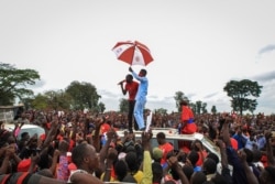 Ugandan musician turned politician Robert Kyagulanyi, also known as Bobi Wine, holds an umbrella as he is introduced to supporters during his presidential rally before being arrested in Luuka, Uganda, Nov. 18, 2020.