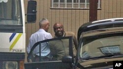 Nigerian ex-militant leader accused of involvement in deadly bombing attacks, Henry Okah, right, is led from the court after appearing for the third time in Johannesburg, Oct. 14, 2010 (file photo)