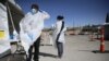 Petugas mengenakan APD di lokasi tes Covid-19 drive-thru di negara bagian COVID-19 di UTEP di El Paso, Texas, 26 Oktober 2020. (Briana Sanchez / The El Paso Times melalui AP)