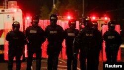 FILE - Police officers stand in formation during a protest in the Loyalist Tigers Bay Area of Belfast, Northern Ireland, April 9, 2021. 