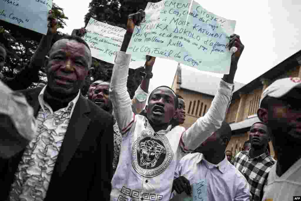 Des Congolais brandissent des pancartes lors d'une manifestation après un service catholique pour commémorer les victimes de la répression de la marche du mois dernier à l'extérieur d'une cathédrale à Kinshasa, le 12 janvier 2018.