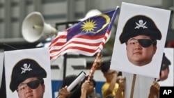 Pengunjuk rasa memegang potret Jho Low yang digambarkan sebagai bajak laut dalam protes di Kuala Lumpur, Malaysia, 14 April 2018. (Foto: