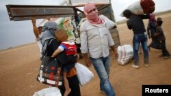 Kurdish Syrian refugees load their belongings on a truck on the Turkish-Syrian border near the southeastern town of Suruc in Sanliurfa province, Sept. 24, 2014.