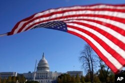 Bendera AS berkibar ditiup angin di Capitol Hill di Washington, Jumat, 19 November 2021. (Foto AP/Carolyn Kaster)