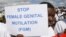 FILE - A Masai girl holds protest sign during an anti-Female Genital Mutilation (FGM) run in Kilgoris, Kenya.
