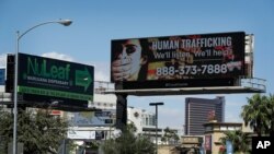 ARCHIVO - Una valla publicitaria en Las Vegas, Nevada, anuncia un número de teléfono nacional al que pueden llamar quienes conozcan o sean víctimas de la trata de personas. Septiembre 21 de 2017.