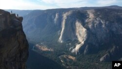 FILE - In this Sept. 27, 2018 file photo, a bride and groom are photographed at Taft Point in California's Yosemite National Park. A Yosemite National Park official says two visitors have died in a fall from the popular overlook. Park rangers are trying to recover the bodies of a man and a woman, Oct. 25, 2018.