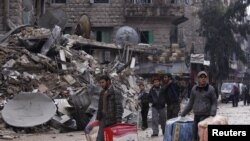 Residents evacuate their houses after being targeted by missiles fired by forces loyal to Syria's President Bashar al-Assad, in Aleppo's al-Mashhad district, Syria, January 9, 2013. 